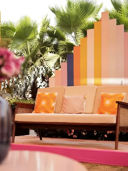 A comfortable and stylish guest seating area with a colorful, geometric backdrop that ties into the 'Spectrum of Love' theme.