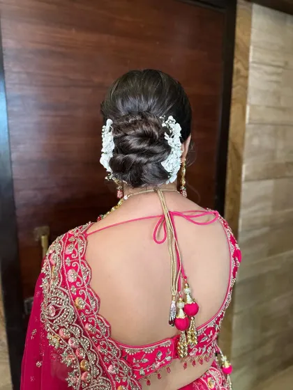 This fresh wedding bun is styled with delicate white flowers and baby's breath. It's a romantic and timeless choice for any bride on her wedding day.