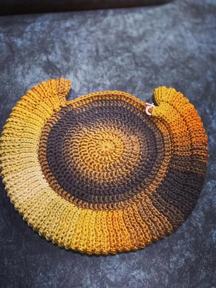 The beginning stages of a round bag, with the yarn cake showing the beautiful color gradient.