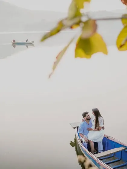A wide-angle view of the couple on the boat, showing the vast, calm lake and other boats in the distance.