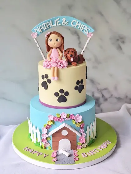 I will always woof you! A two-tier cake for a dog lover, featuring a doghouse, paw prints, and custom figurines of the birthday girl and her pup.