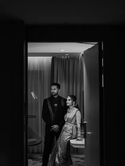 A classic black and white portrait of the couple, capturing a moment of quiet elegance during their reception.