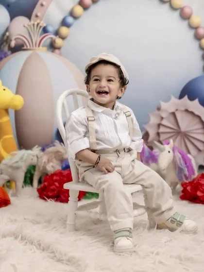 A bright smile for a big milestone. This little boy is all dressed up and ready to party in our colorful and imaginative fantasy-themed studio set.