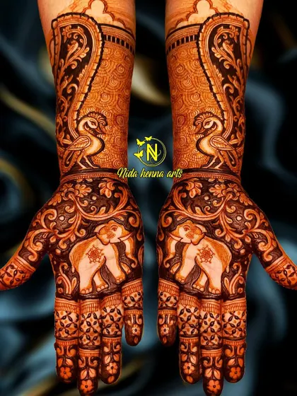 A designer mehandi featuring an animal theme. This symmetrical design has majestic elephants on the palms and graceful peacocks on the wrists, perfect for a bride who loves traditional motifs.