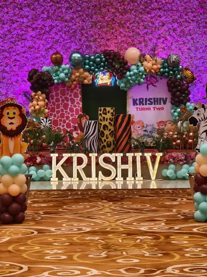 A grand jungle-themed stage for a second birthday party. I used animal print props, character cutouts, marquee letters, and a lush balloon arch to create a vibrant safari look.