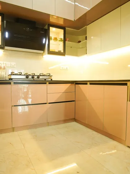 Another angle of the U-shaped kitchen, highlighting the seamless integration of the chimney and the combination of different cabinet styles. The marble-look flooring adds to the elegant feel.