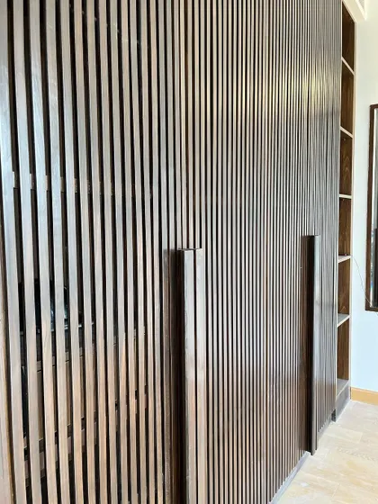 Not all handles are bought from a store. For this wardrobe, we designed and crafted the handles on-site from the same wood, creating a seamless and integrated look that is truly custom.