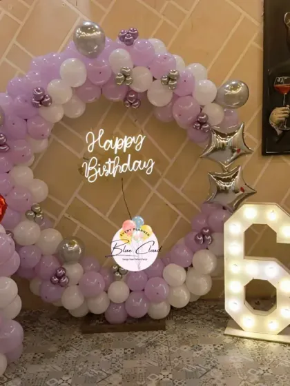 A purple and white balloon ring with silver accents and heart-shaped foils for a 6th birthday.