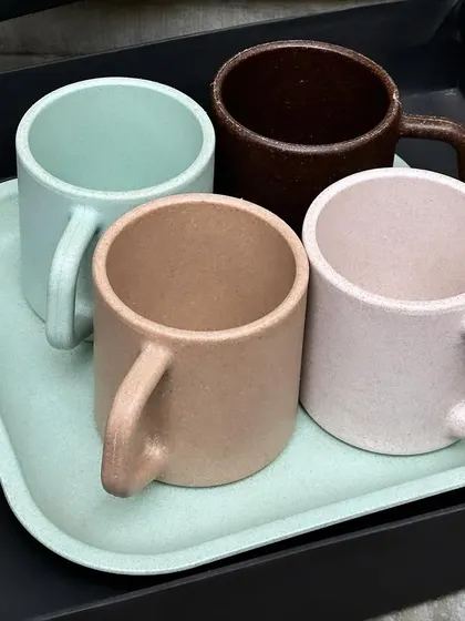 We offer sustainable and stylish corporate gifting solutions, such as this set of four eco-friendly mugs made from natural materials, presented on a matching tray.
