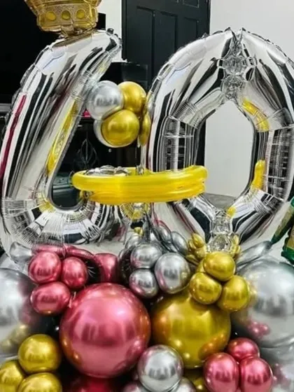 A close-up of a balloon bouquet for a 40th birthday, featuring large silver number balloons.