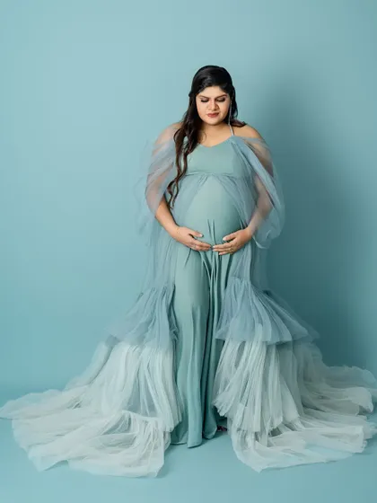 This full-length portrait showcases the incredible texture and flow of the layered blue gown, creating a truly show-stopping image.