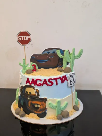 A Disney Cars themed cake for a 3rd birthday. This cake features Lightning McQueen and Mater, complete with fondant cacti and a Route 66 sign.