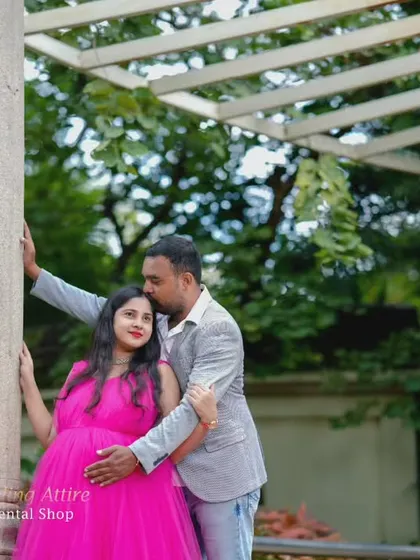 A sweet couple's moment during a maternity shoot featuring our dark pink ruffled gown. This dress works wonderfully for both solo and partner photos, adding a pop of color and romance.