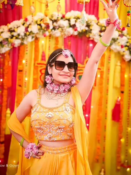 The bride strikes a fun, celebratory pose with sunglasses during her Haldi. This photo captures the high energy and joyful spirit of the event.
