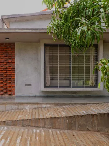 The accessible ramp on the east side of "Aamra," leading up to the verandah. The design ensures the house is welcoming to all, with thoughtful details like the outdoor shower head.