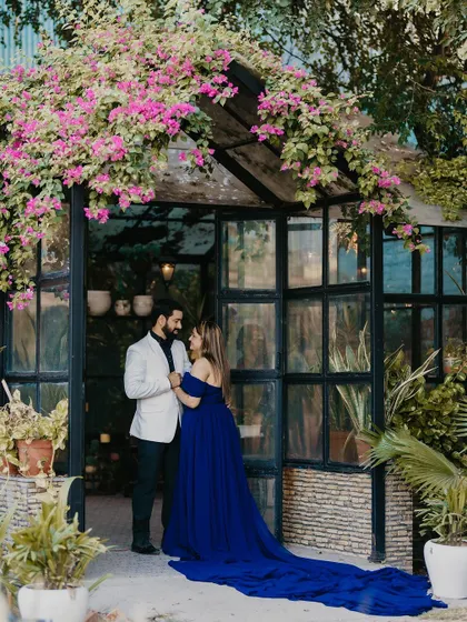A romantic portrait in a beautiful greenhouse setting, with her long blue trail gown adding a touch of drama.
