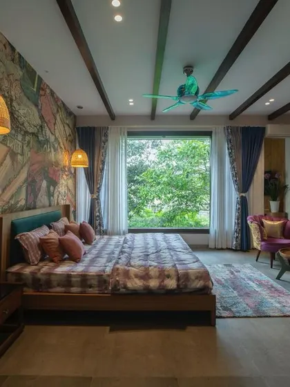 This bedroom combines bold artistic expression with natural elements. A vibrant, comic-book style mural serves as a headboard, while a large window offers a peaceful view of lush greenery, balancing energy with tranquility.