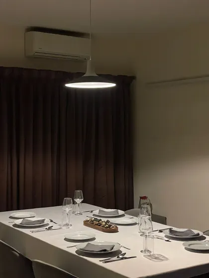 The mood is set for an evening of fine food and wine. The soft lighting and elegant table create a warm and inviting space for a private dinner.