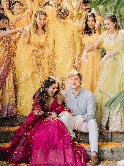 A shower of marigold petals for the happy couple. The bride's pink lehenga stands out beautifully against the yellow-clad guests.