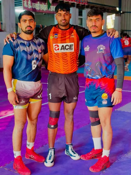 Three of my senior players, representing different teams in the Yuva Kabaddi Series, standing together at our academy.