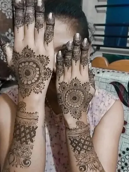 A playful pose showing the back-hand mandala designs. This style is perfect for any occasion, from parties to pujas.