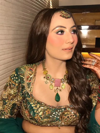 A close-up of the colorful mehandi makeup, with green and purple eyeshadow.