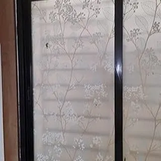 A frosted film with a subtle, white floral vine pattern. This is an elegant and understated way to add privacy to windows without overwhelming the room's decor.