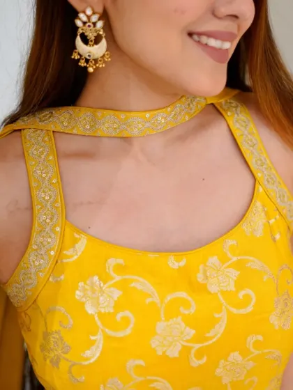 Sunshine and elegance in every thread. A close-up of the beautiful floral embroidery on this yellow blouse.