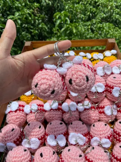 Holding up a pair of my pink bee keychains. This custom color was a fun project and shows the possibilities for your own unique order.