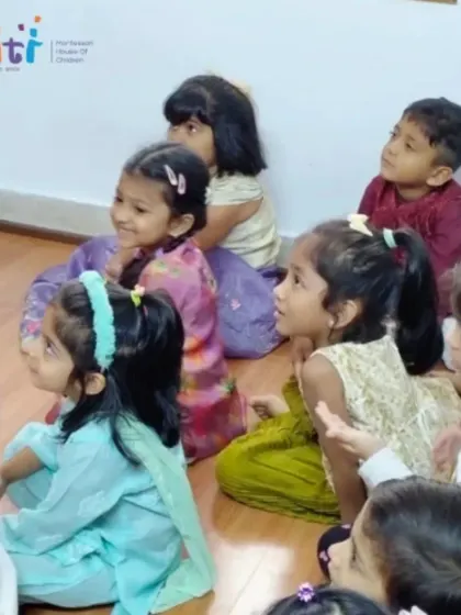 A group of girls in beautiful traditional outfits listens with wide-eyed wonder. Our festival celebrations are a vibrant and joyful part of the Smiti experience.