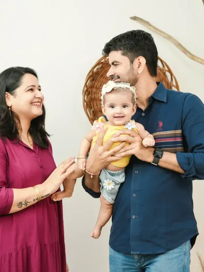 A happy family portrait celebrating a six-month milestone. This image captures the joy and love of parents interacting with their smiling baby girl.