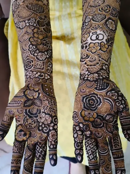 A full view of the engagement bride's mehndi, showing the ring design on one palm and other beautiful floral patterns.