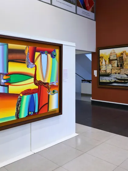 A wide shot of our gallery space, featuring a vibrant abstract by Bose Krishnamachari. We invite you to step in and find what moves you.