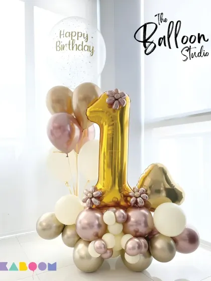 Celebrating a first birthday in style! This elegant gold and rose-gold balloon arrangement is a beautiful centerpiece for a milestone celebration.