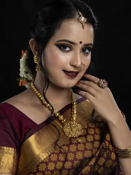 This studio portrait showcases a bold and defined bridal look. The sharp winged eyeliner, deep maroon lip, and perfectly sculpted features are ideal for brides wanting a high-impact, photogenic style for their wedding day.