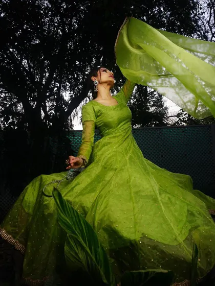 A dynamic shot capturing the Anarkali's dupatta as it flies in the air. This adds a sense of freedom and movement to the image, making it feel alive.
