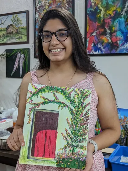 A participant proudly displays her painting of a doorway framed by vibrant bougainvillea. Our workshops often feature beautiful, picturesque scenes.