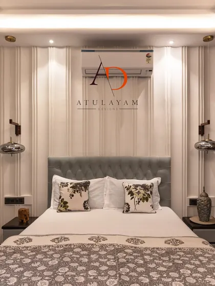 A simple yet stylish bedroom with a captivating feature wall of vertical grooves, a tufted light blue headboard, and modern pendant lights.