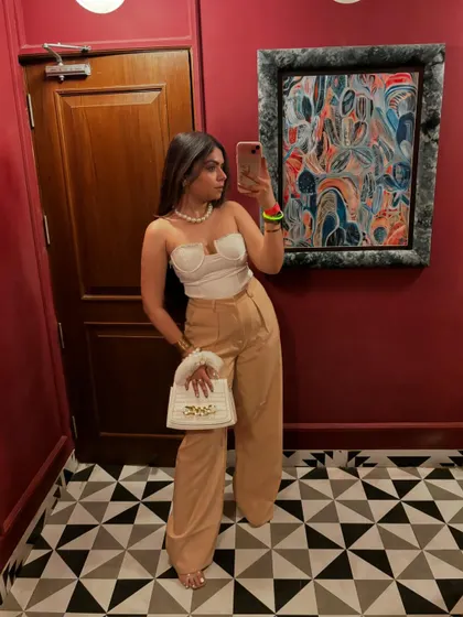 A late-night fashion post featuring a white corset top and beige wide-leg trousers. A classic and elegant combination.