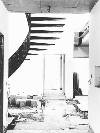 Another artistic shot of the staircase under construction, emphasizing its elegant curves and the stark beauty of the raw materials.