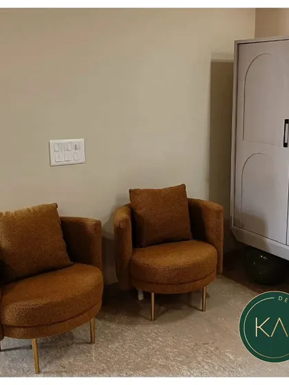 A pair of comfortable, barrel-back armchairs in a warm brown fabric. These chairs were designed to be both stylish and inviting, perfect for creating a cozy conversation nook.
