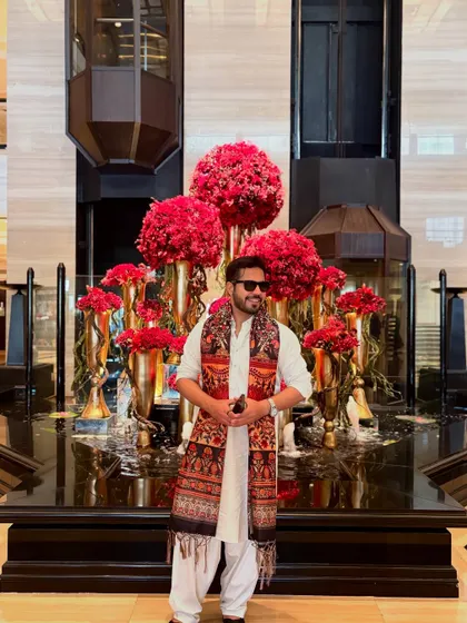 A grand pose in front of an opulent floral decoration, showing I can match the grandeur of any venue.