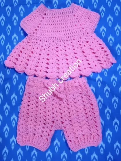 A simple and sweet two-piece baby set, including a pink peplum-style top and matching shorts with a drawstring waist.