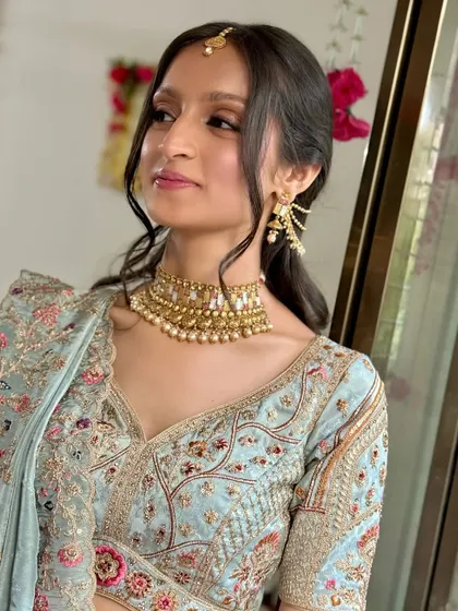 The bride looking elegant and poised, her makeup perfectly complementing her pearl and gold jewelry.