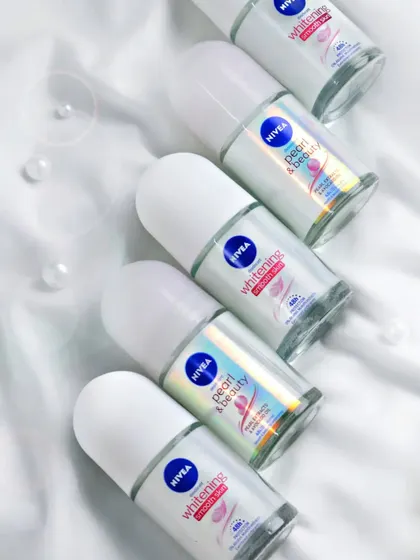 A clean, high-key flat lay of Nivea roll-on deodorants on a silky white fabric. This type of shot is perfect for e-commerce, showcasing product variety in a crisp and appealing way.