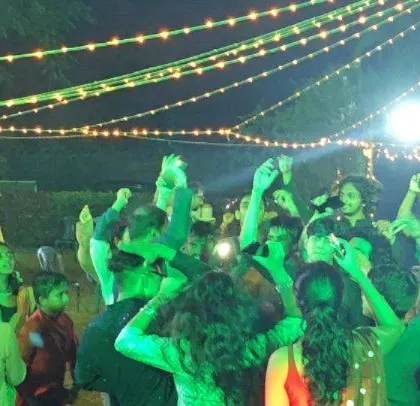 The crowd is having a great time, with some guests lifted onto shoulders.