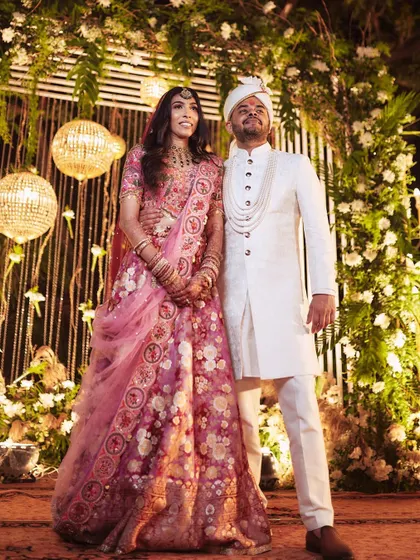 A classic portrait of the couple against their wedding decor. Pallavi's soft pink look is both traditional and modern.