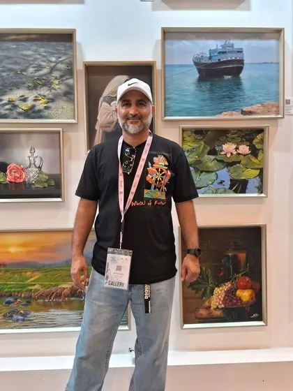 A visitor posing with the diverse artworks of Zeinab Sarkhosh.