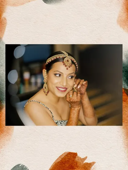 A beautiful portrait of the bride putting on her earrings, framed with a soft, artistic border. This highlights the jewellery and the bride's happy anticipation.