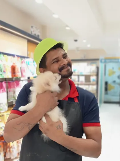 A tender moment between a groomer and a tiny Pomeranian puppy during our Grooming Fest. We believe in building a bond of trust and affection with every pet, making their experience a happy one.